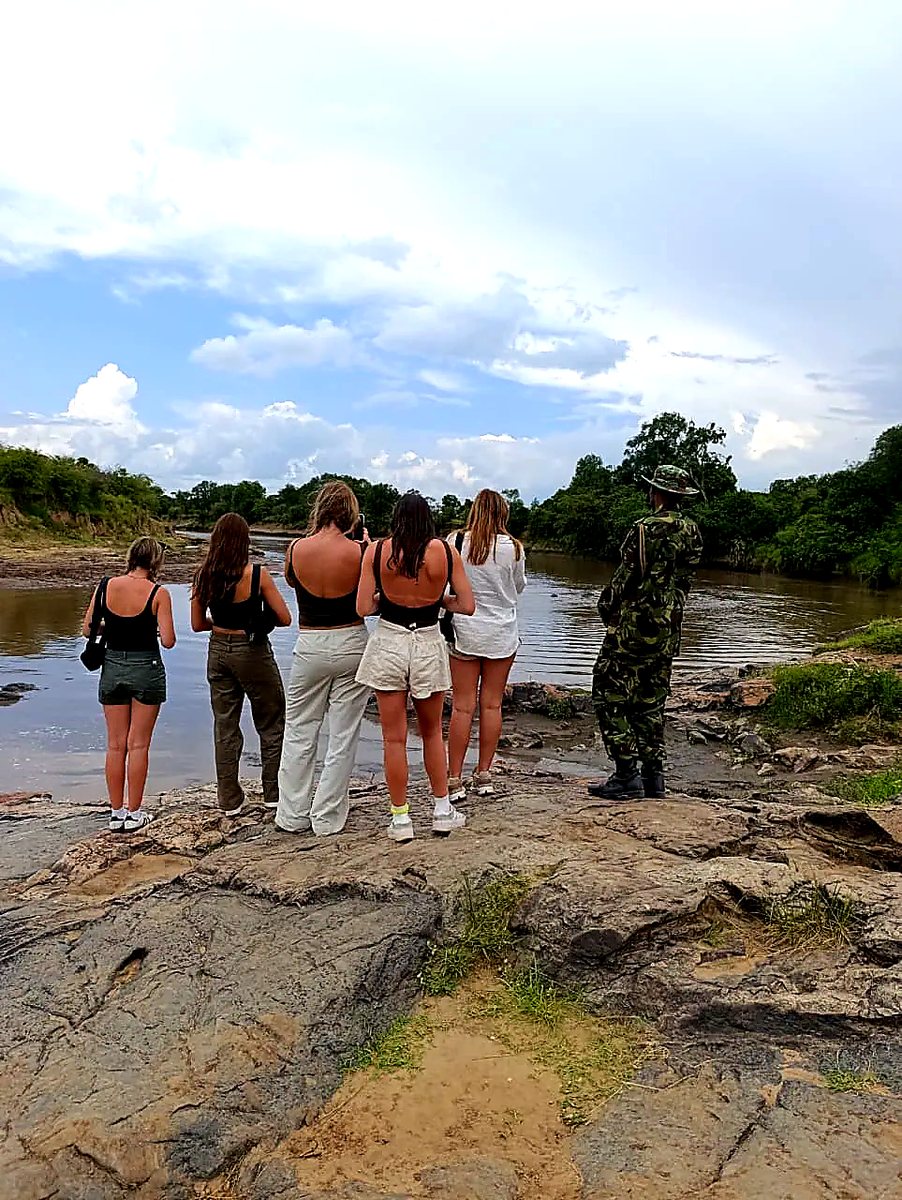 Guests and ranger standing at the Mara River bank